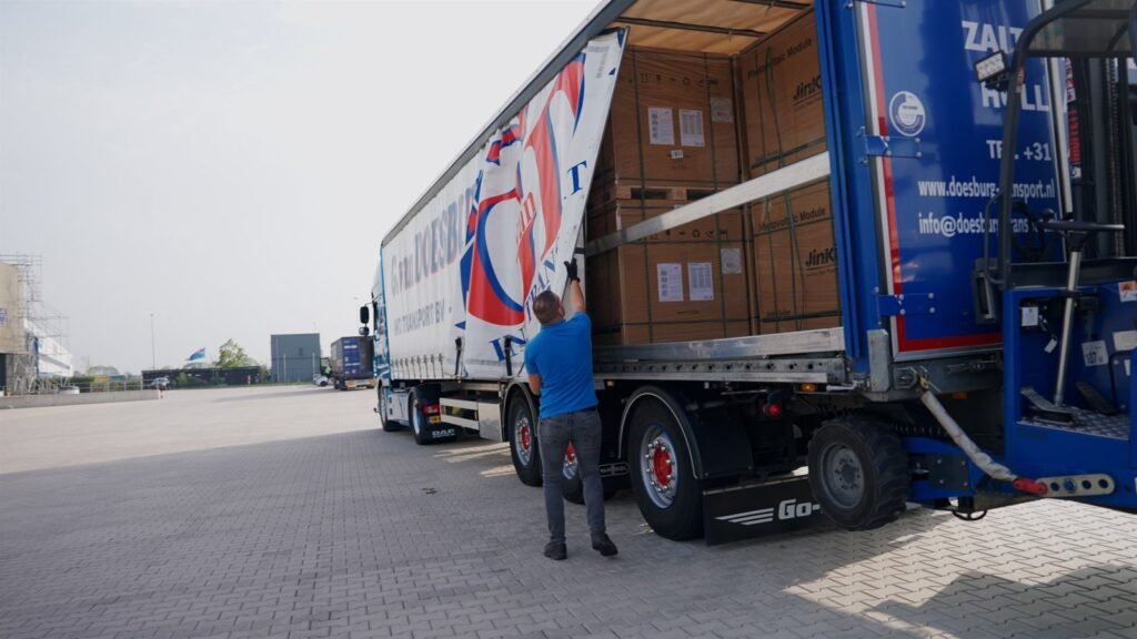Driver next to an open GD-iTS trailer being loaded