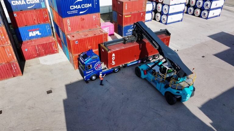 Reach stacker moving a sea container between stacked containers