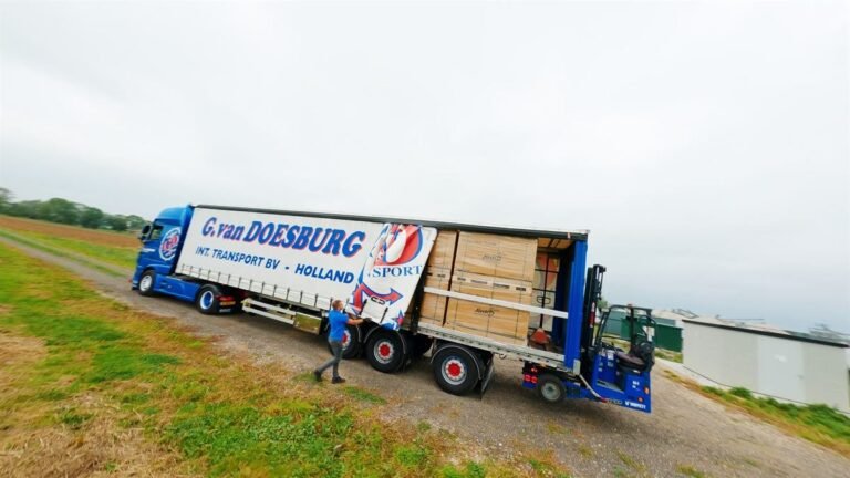 GD-iTS truck with trailer driving along a dyke through the polder landscape