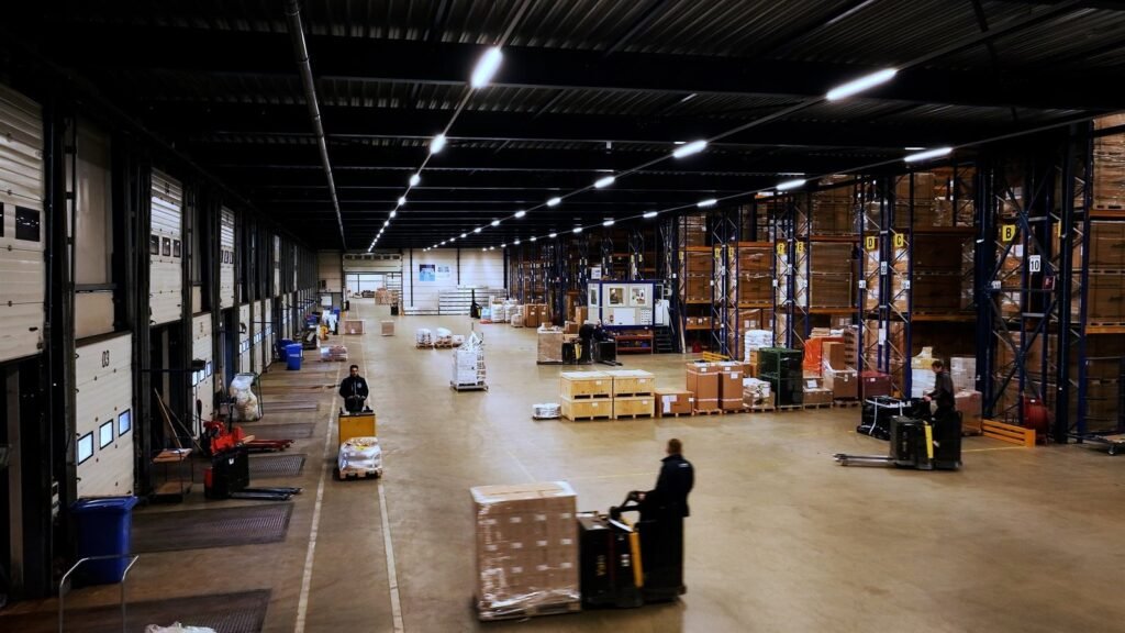 Employees at work in a spacious GD-iTS warehouse hall, with pallets and loading docks